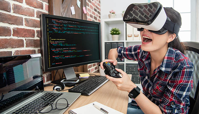 A female game developer with VR headset and gamepad